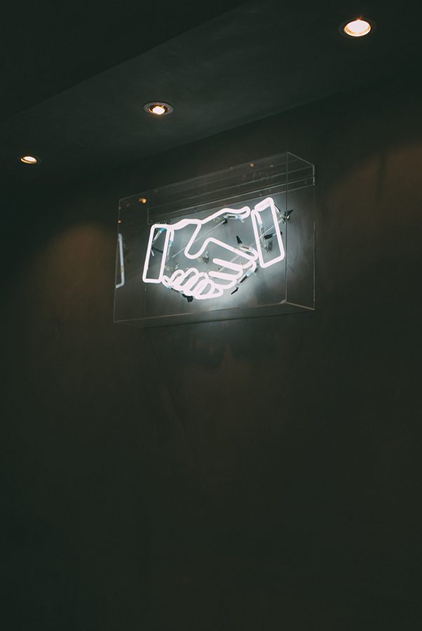 charles-deluvio-AT5vuPoi8vc-unsplash_600px Shaking hands neon sign